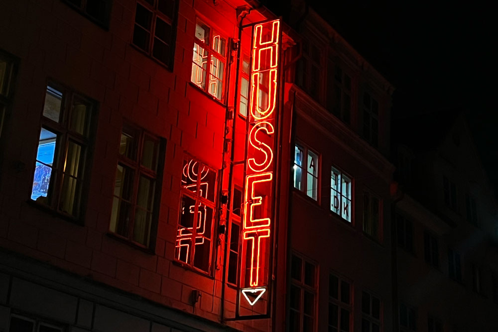 Red neon sign outside Huset