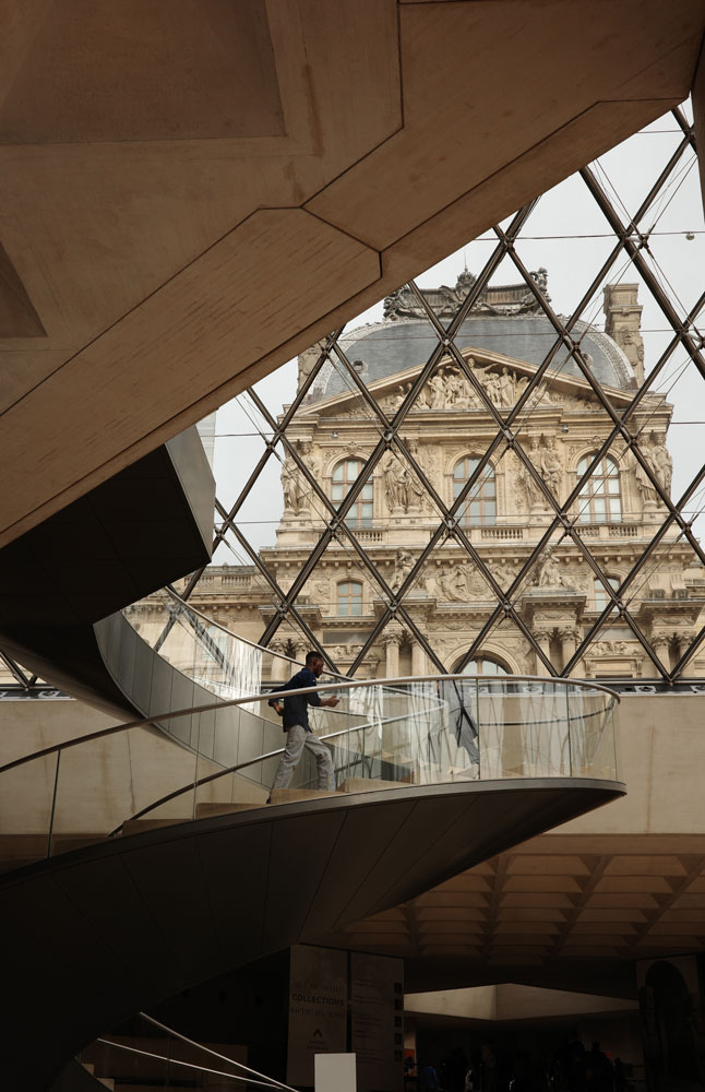 Person running up the stairs in the Louvre